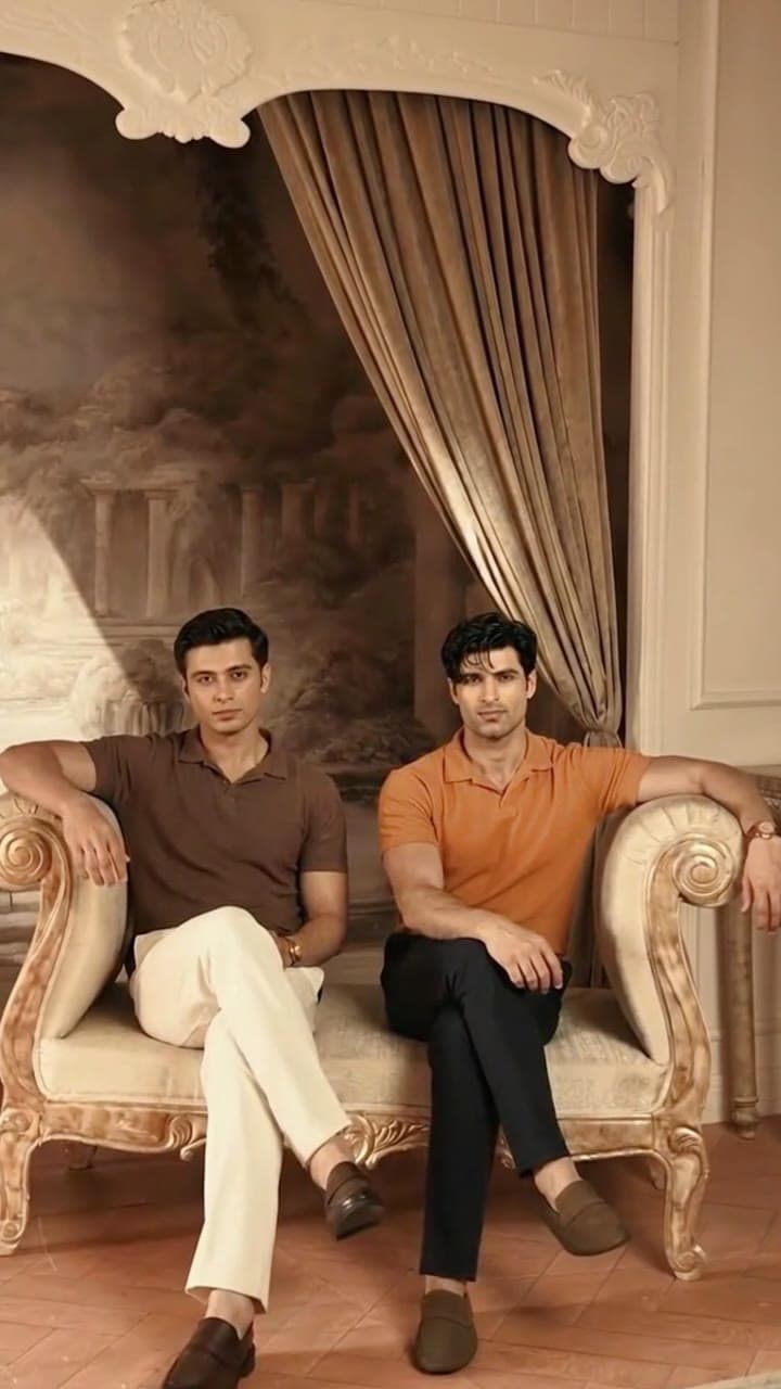 Two men seated on an ornate sofa in a heritage room
